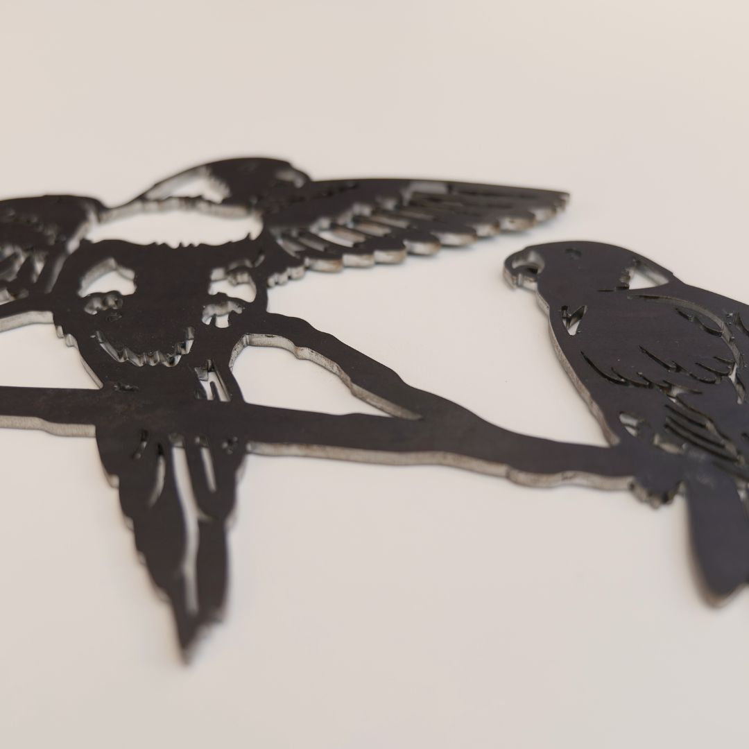 The "Pair of Lorikeets" by Metalbird Australia is a premium corten steel silhouette showing two birds on a branch. Its flat black finish pops against any background, making it an ideal gift for art lovers.