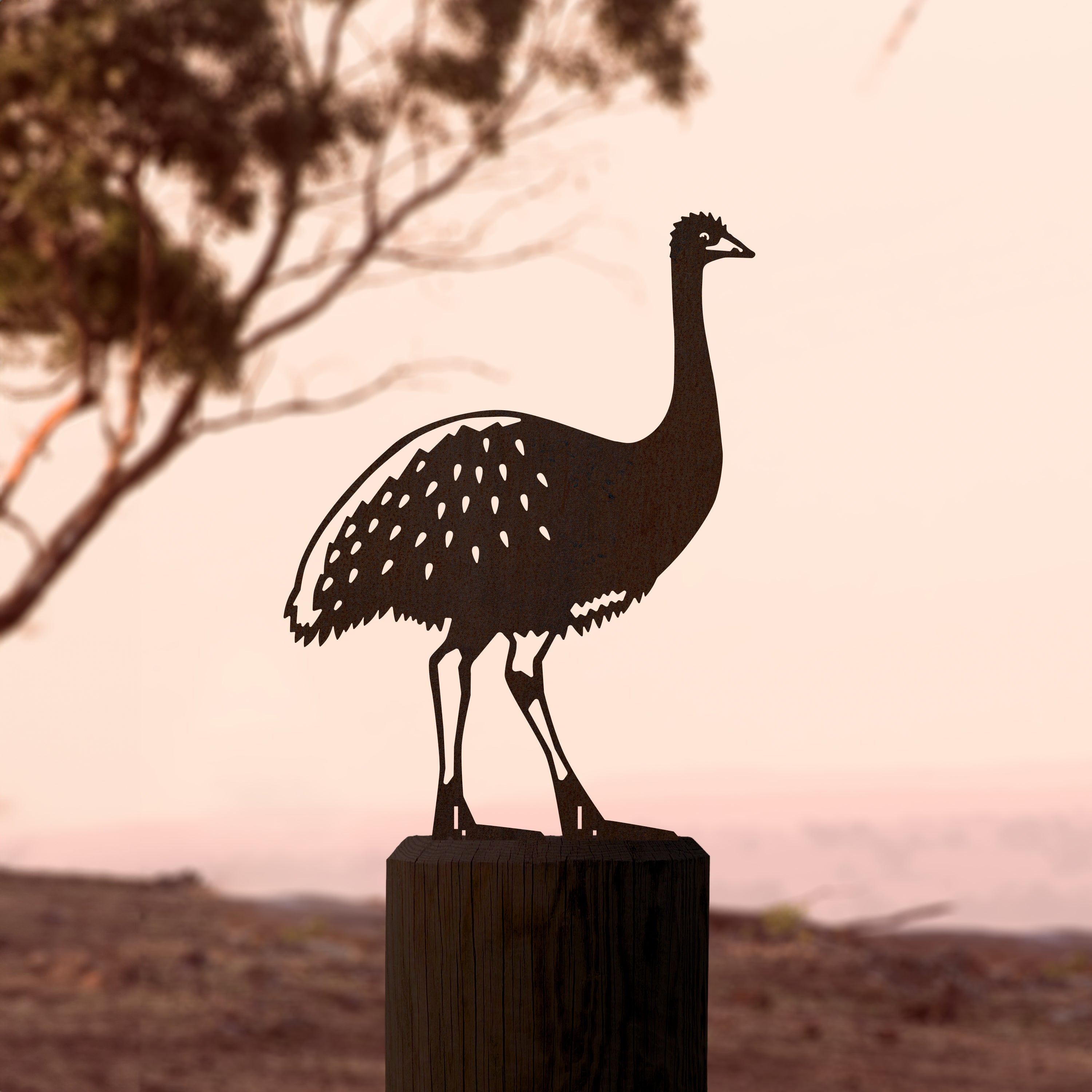 The Metalbird Australia Emu is a premium metal silhouette perched on a wooden post, creating striking outdoor yard art against natural landscapes.