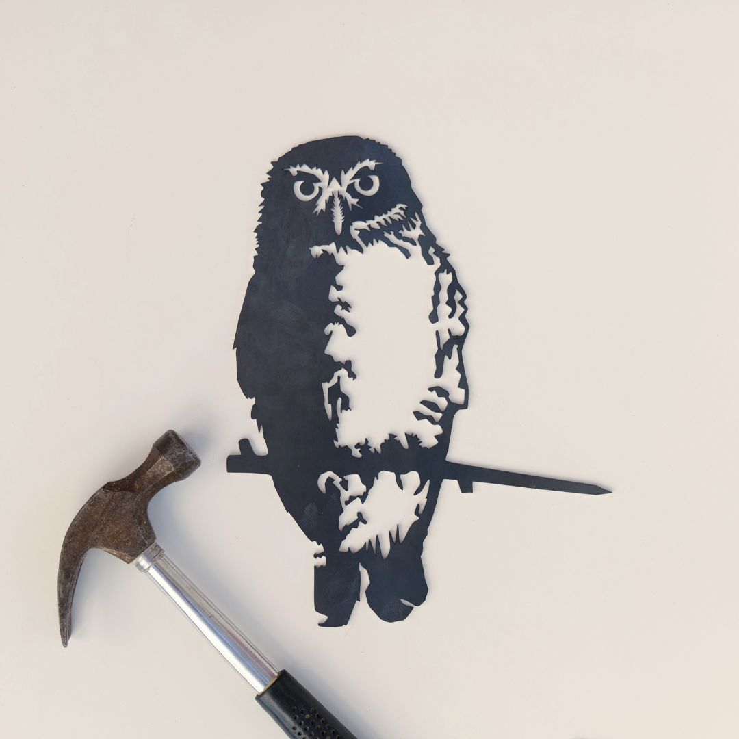 Southern Boobook Owl silhouette beside a hammer on a pale background.