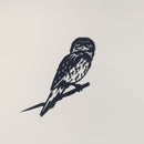 A black metal cutout of a Tawny Frogmouth by Metalbird Australia perches on a branch against a white background, showcasing detailed features—perfect for one-of-a-kind yard art or as a thoughtful gift.