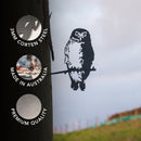 A striking piece of outdoor garden decor, the Southern Boobook Owl by Metalbird Australia is a metal silhouette crafted from 3mm Corten Steel and perched on a branch attached to a tree. Three circles highlight its features: Made in Australia, Premium Quality, and durable 3mm Corten Steel. With the fence and sky visible in the background, this premium Metalbird sculpture adds charm to any natural setting.
