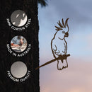 A Cockatoo metal bird silhouette by Metalbird Australia is mounted on a tree. Circular text highlights: 3mm Corten Steel, Made in Australia, and Premium Quality. The sunset sky in the background enhances the striking detail of this unique Corten steel bird.