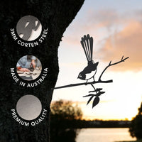 A Metalbird Australia Willie Wagtail garden ornament, crafted from premium 3mm Corten steel, is beautifully silhouetted against a lakeside tree at sunset. Three circles highlight its durable Corten steel construction, authentic Australian backyard décor style, and outstanding quality with corresponding images.