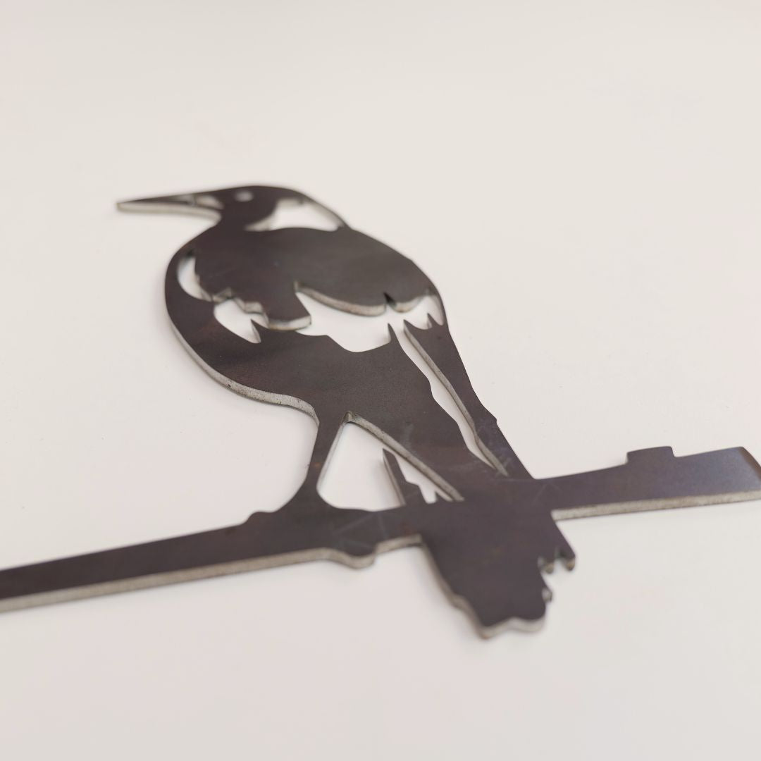 Close-up of the Magpie steel silhouette and cut-out wing markings on a pale surface.