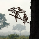 The Pair of Lorikeets by Metalbird Australia is a corten steel silhouette of two birds on a branch, one with open wings, set against a misty landscape with trees and an open sky in the background.