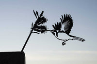 Silhouette of the Metalbird Seconds - EASTERN SPINEBILL by Metalbird Australia - Seconds, capturing a bird with outstretched wings feeding from a flower—ideal for highlighting the unique charm of metal bird imperfections.